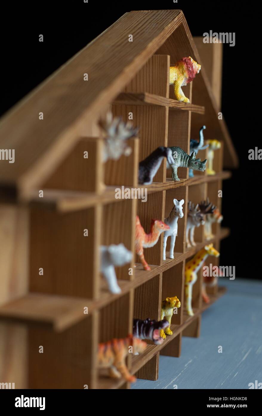 Un piccolo di legno casa con divisori, riempito con plastica toy animali. Foto Stock
