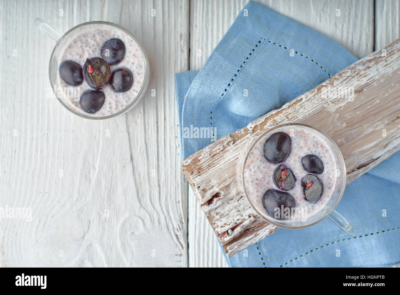 Budino di Chia con uve sul bianco tavolo in legno vista superiore Foto Stock