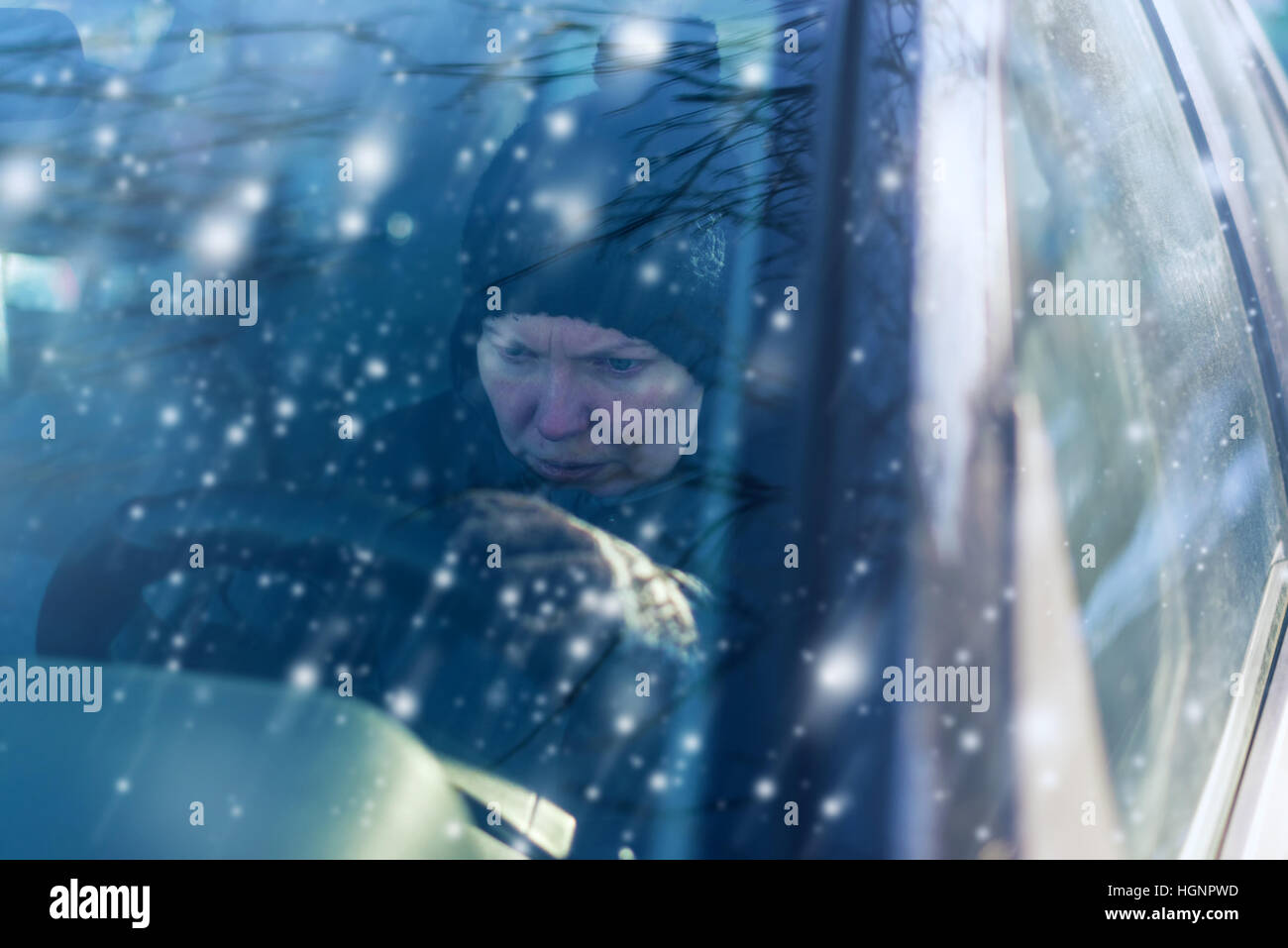 Giovani adulti donna caucasica non può avviare auto su freddo inverno nevoso giorno Foto Stock