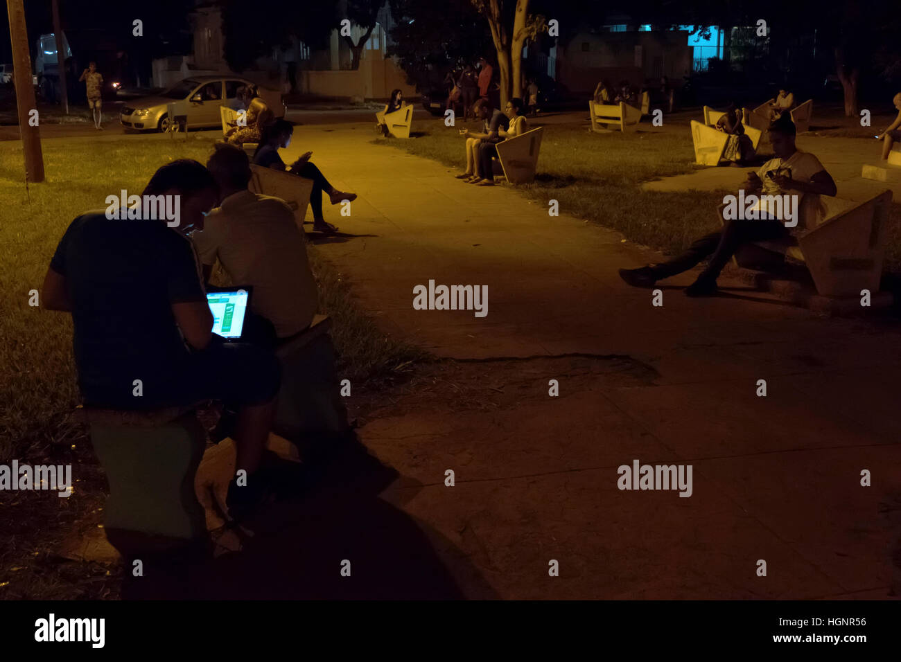 L'Avana, Cuba. Il popolo cubano tramite telefono cellulare, telefono cellulare, smartphone e tablet ipad per internet wi-fi in un parco di Miramar Foto Stock