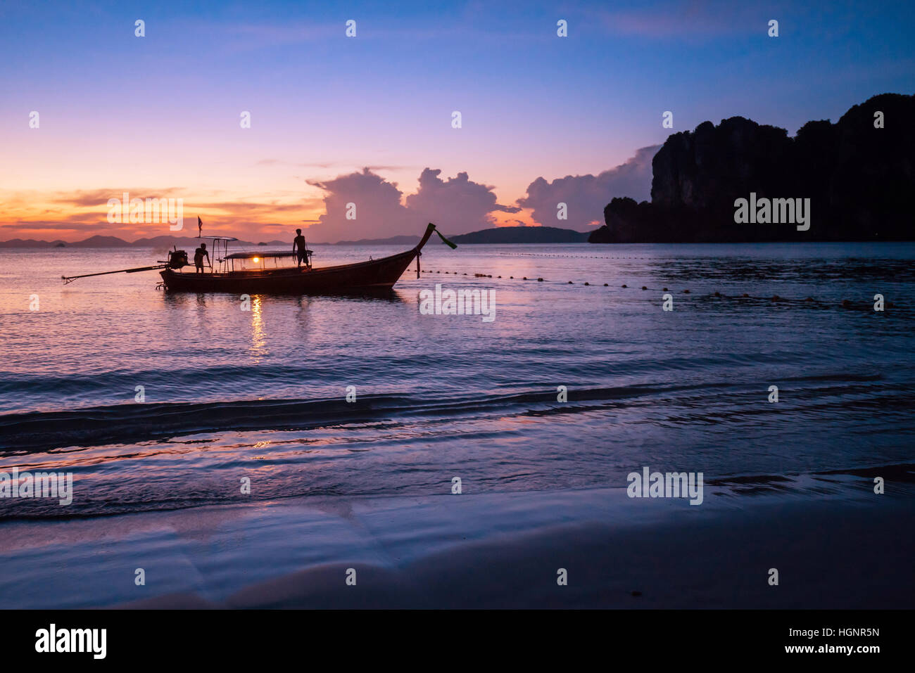 Isola tropicale tramonto con barche di pescatori in silhouette, con arancia e toni di blu in Phi-Phi Leh island Foto Stock