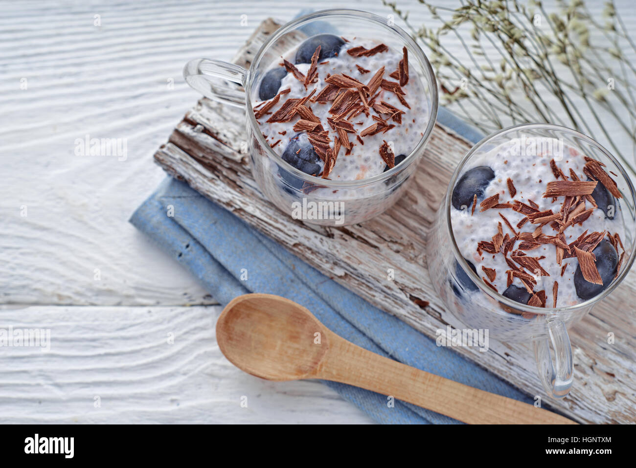 Budino di Chia con uva e scaglie di cioccolato sul bianco tavolo in legno vista superiore Foto Stock