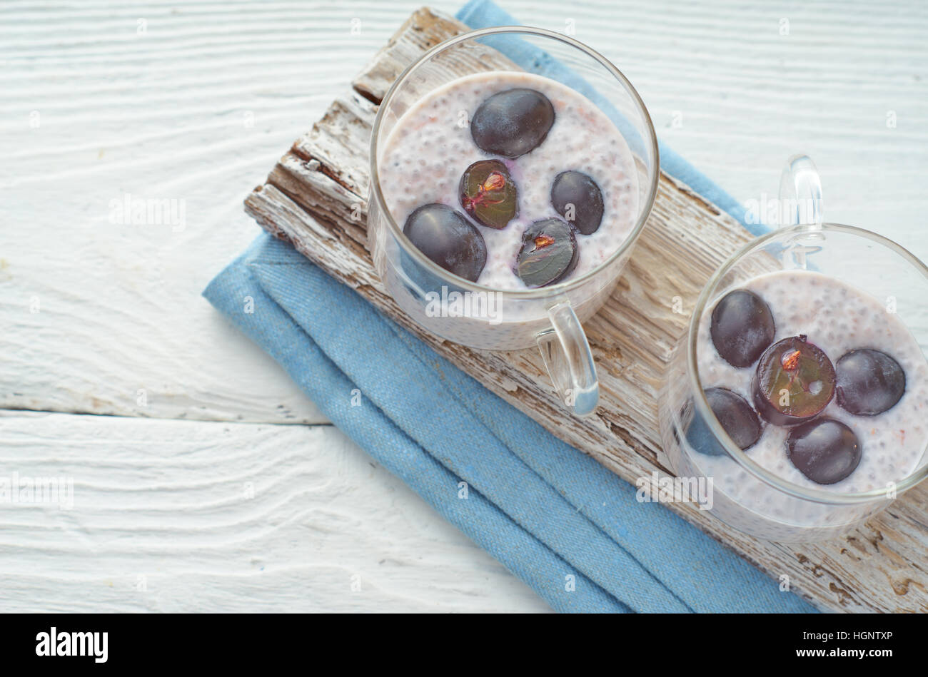 Budino di Chia con uve sul bianco tavolo in legno Foto Stock
