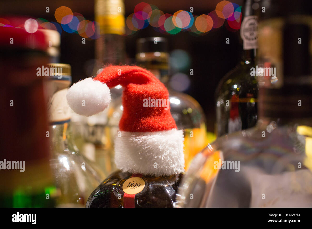 Una collezione di bottiglie di spirt a Natale in una casa di famiglia, una bottiglia ha un piccolo rosso e padre bianco Natale hat. Foto Stock