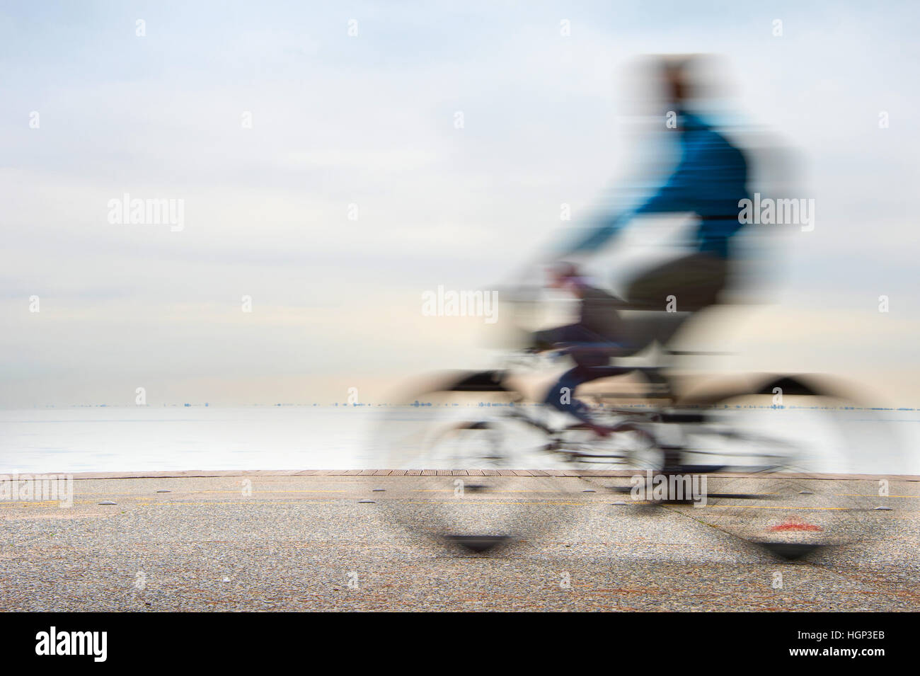 Un gruppo di ciclisti sul terrapieno di fronte al mare Foto Stock