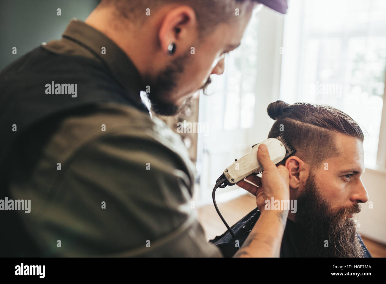 Barba uomo getting haircut al Barber shop. Parrucchiere il taglio dei capelli del cliente al salone. Foto Stock