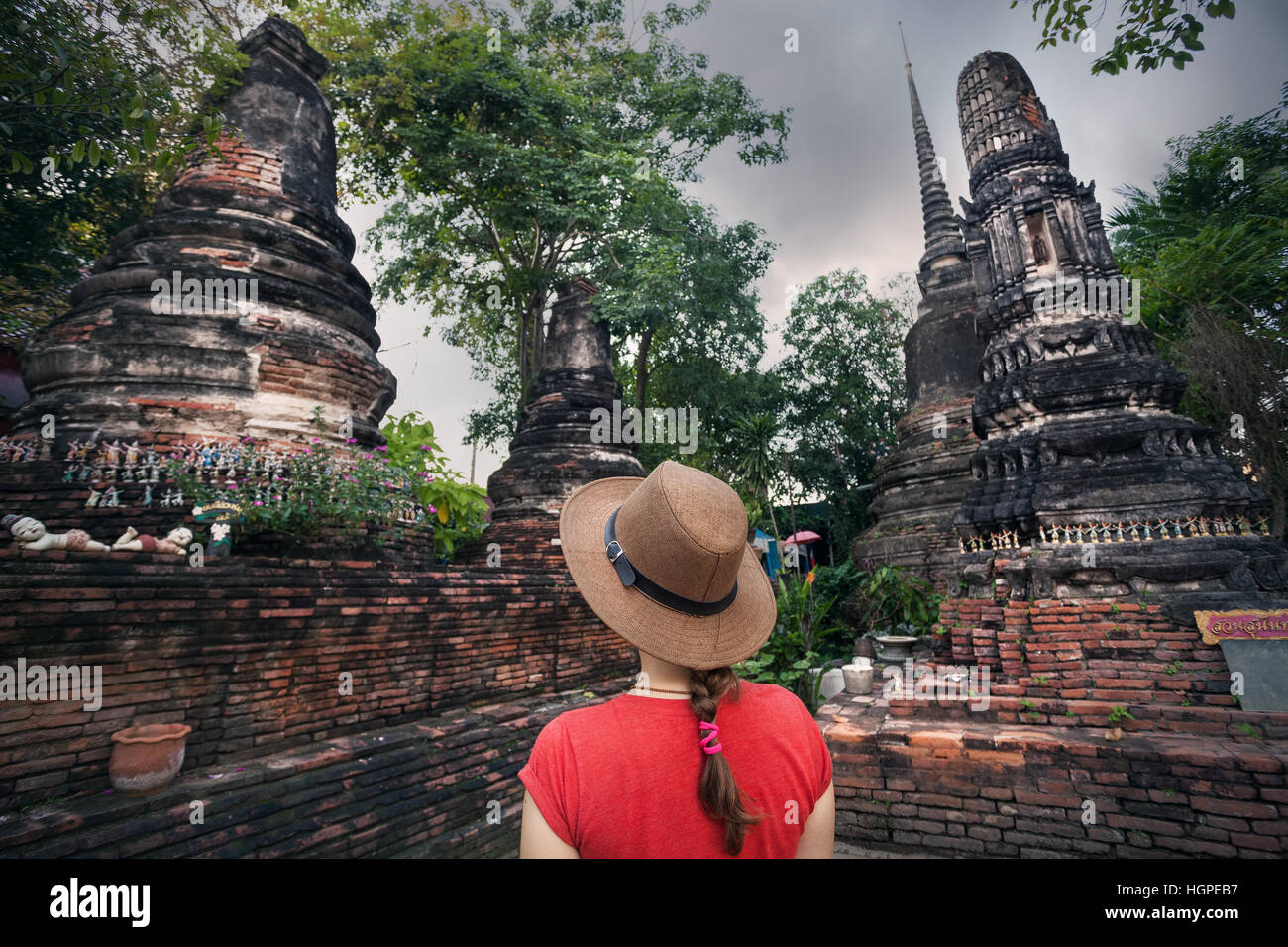 Donna in hat guardando antichi stupa in rovina in Ayutthaya, Thailandia Foto Stock