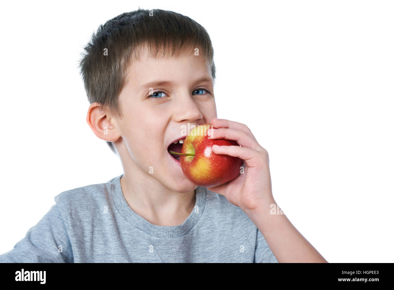 Felice ragazzo sano mangiare apple bianco isolato Foto Stock