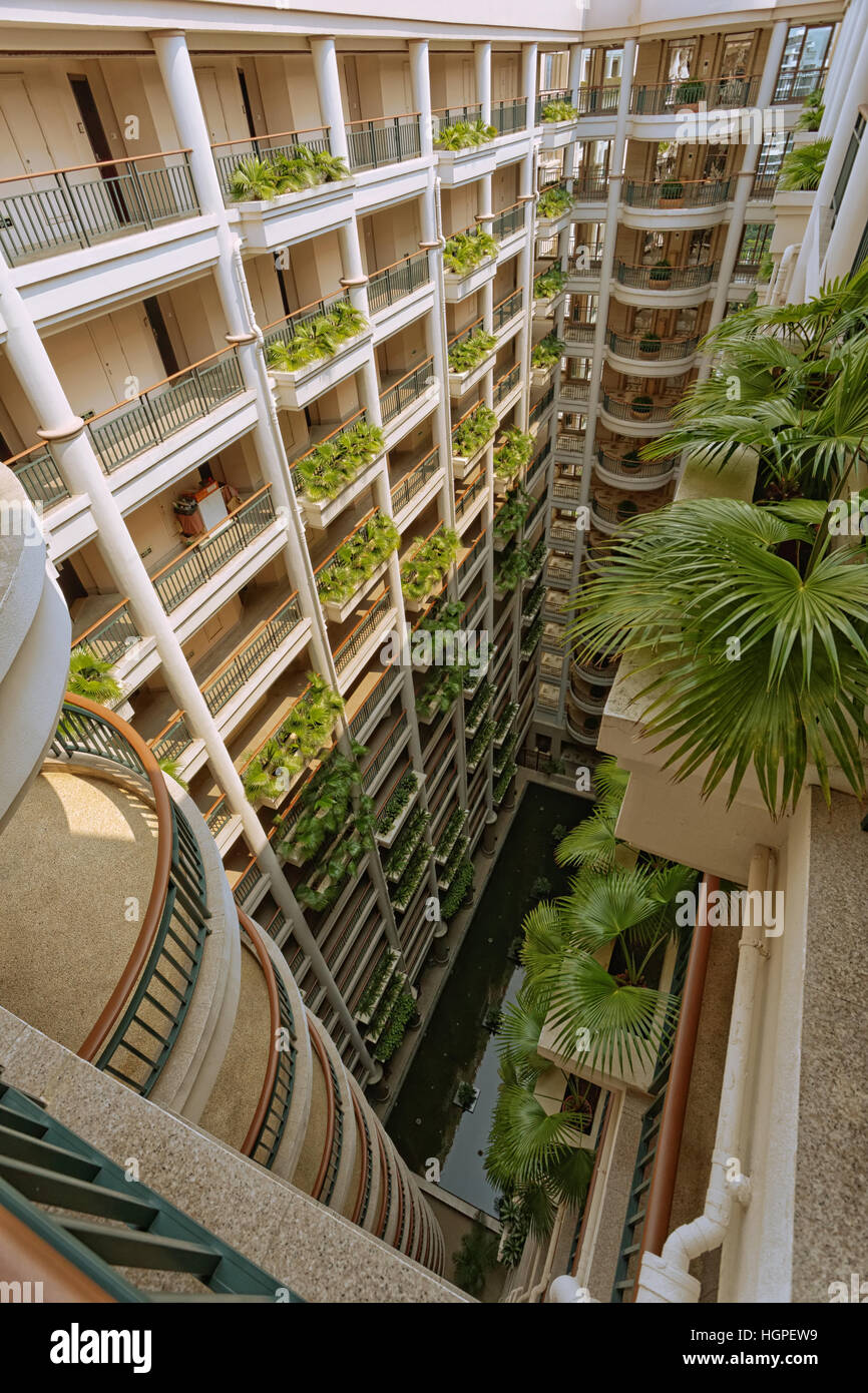 Vista superiore dell'atrio della grande e moderno hotel multipiano. Vi è una piscina al piano terra. Foto Stock