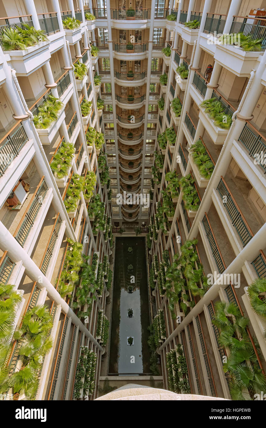 Vista superiore dell'atrio della grande e moderno hotel multipiano. Vi è una piscina al piano terra. Foto Stock