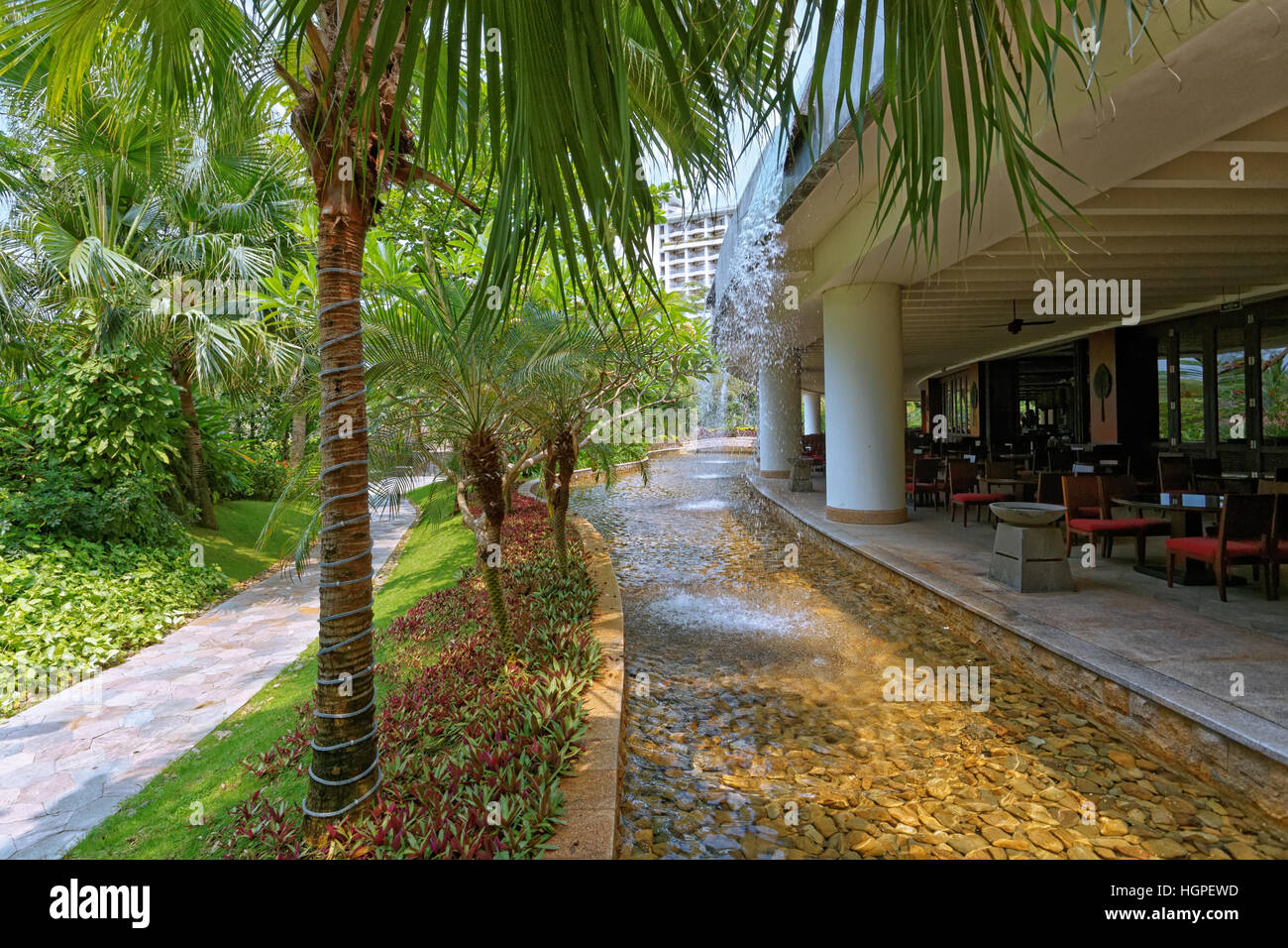 Corte interna dell'hotel di grandi dimensioni con alberi tropicali e fiori, giardini, piscine, aprire spazi interni, cascate ect. Foto Stock