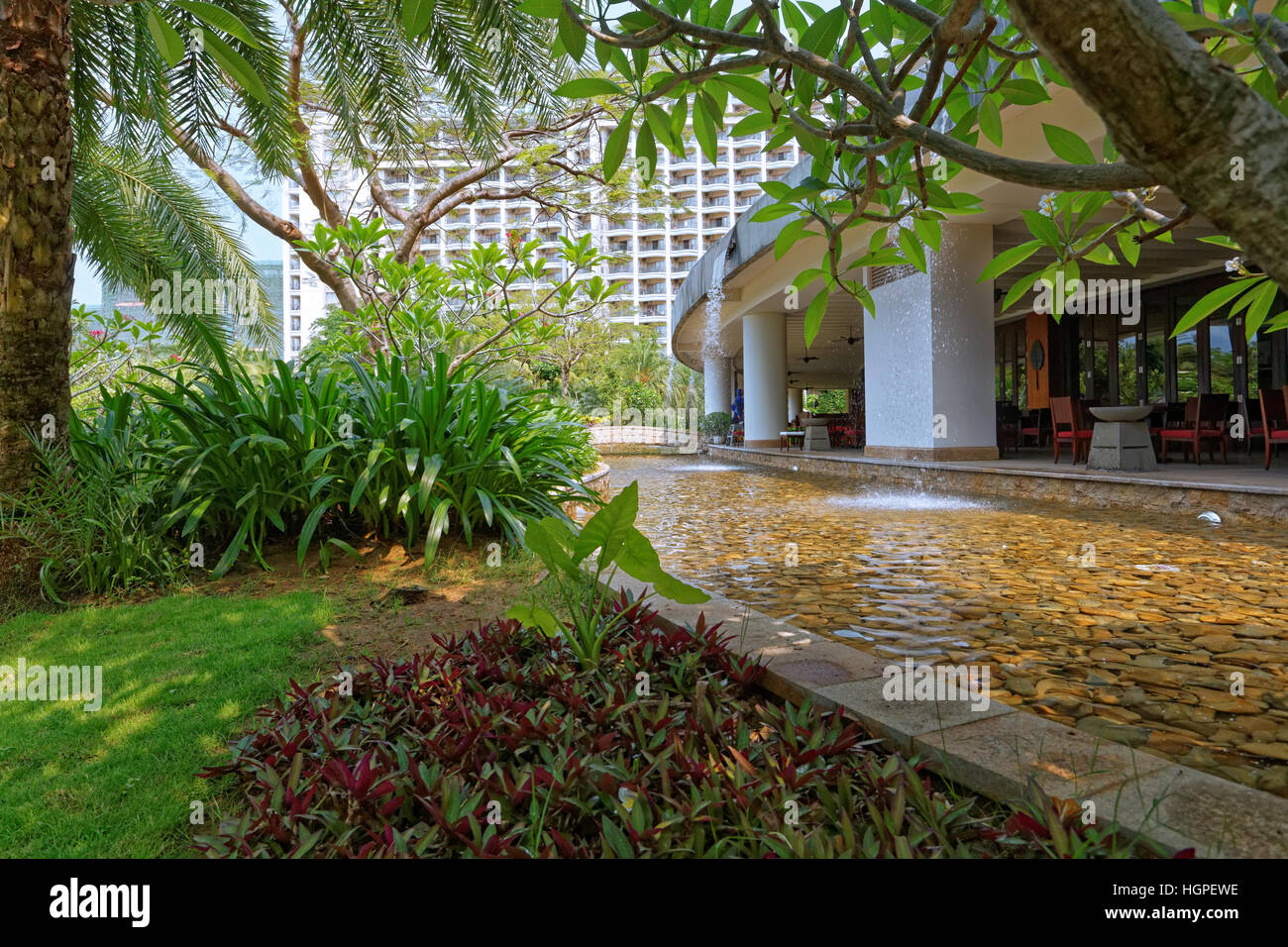 Corte interna dell'hotel di grandi dimensioni con alberi tropicali e fiori, giardini, piscine, aprire spazi interni, cascate ect. Foto Stock