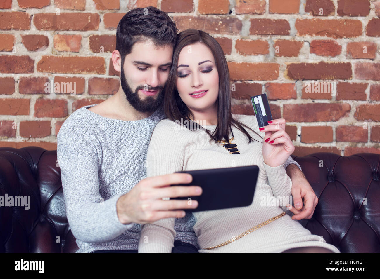 Giovane shopping on line dal tablet e carta di credito indoor Foto Stock