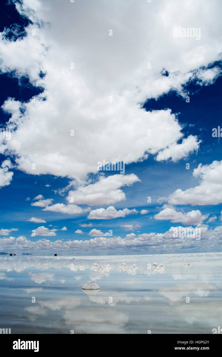 Profondo cielo blu con lunghe e bianche nuvole riflesso in acqua di sale di Uyuni Appartamenti Boliva Foto Stock