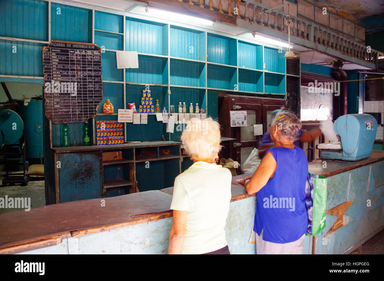 Due donne anziane guardando quasi vuoto negozio scaffali in uno stato di proprietà store in Havana, Cuba Foto Stock