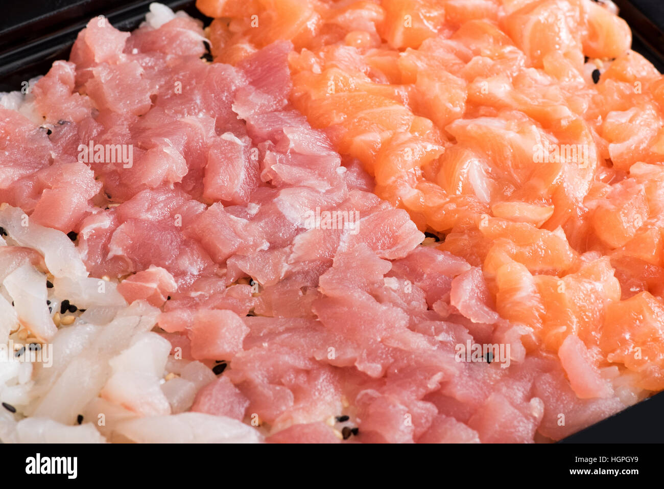Close up ritaglio di piatto riempito con bass, il tonno e i filetti di salmone piccoli pezzi e tartare sauce Foto Stock