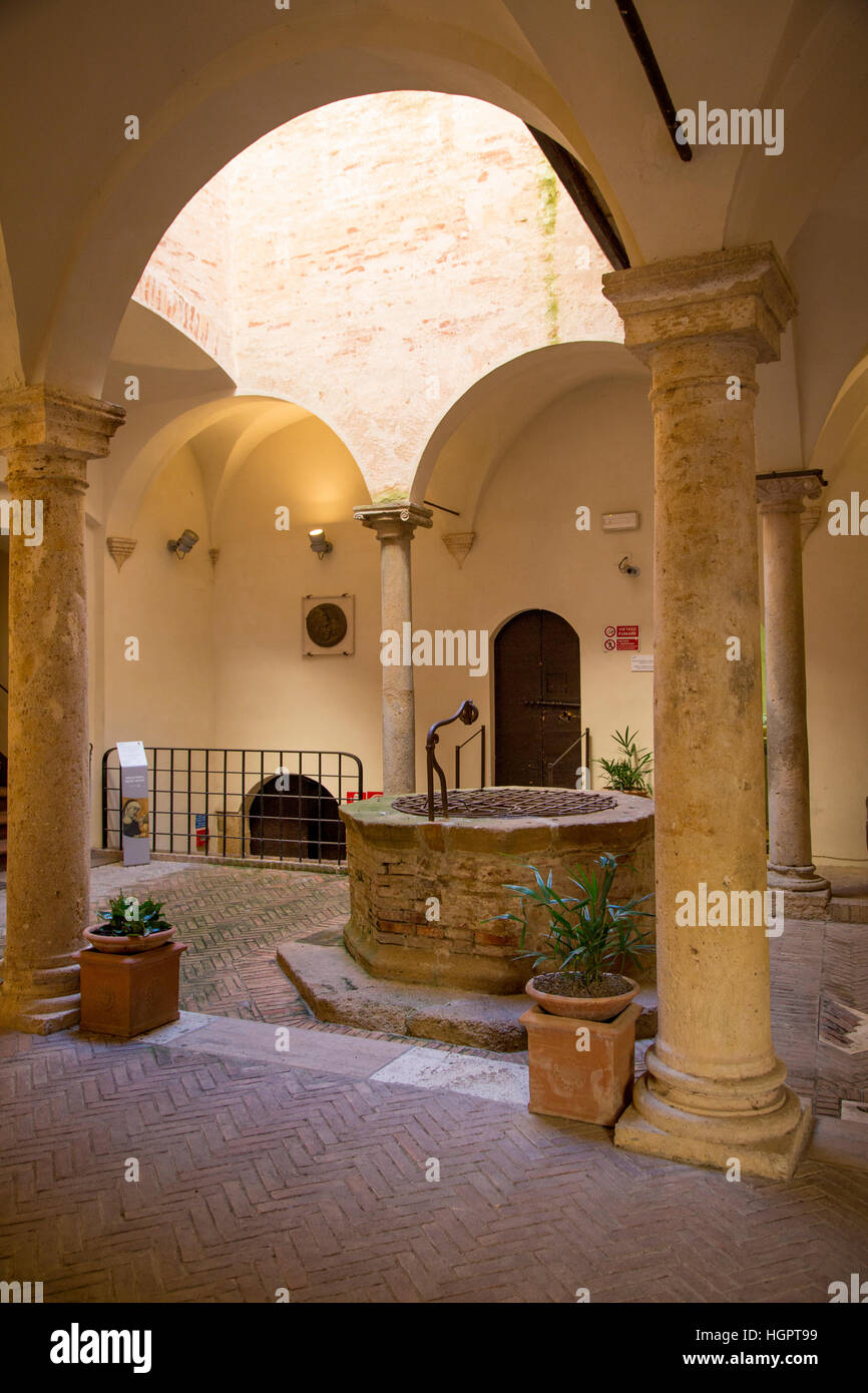 Antico pozzo di acqua all'interno del Museo Diocesano nella città medievale di Pienza, Toscana, Italia Foto Stock
