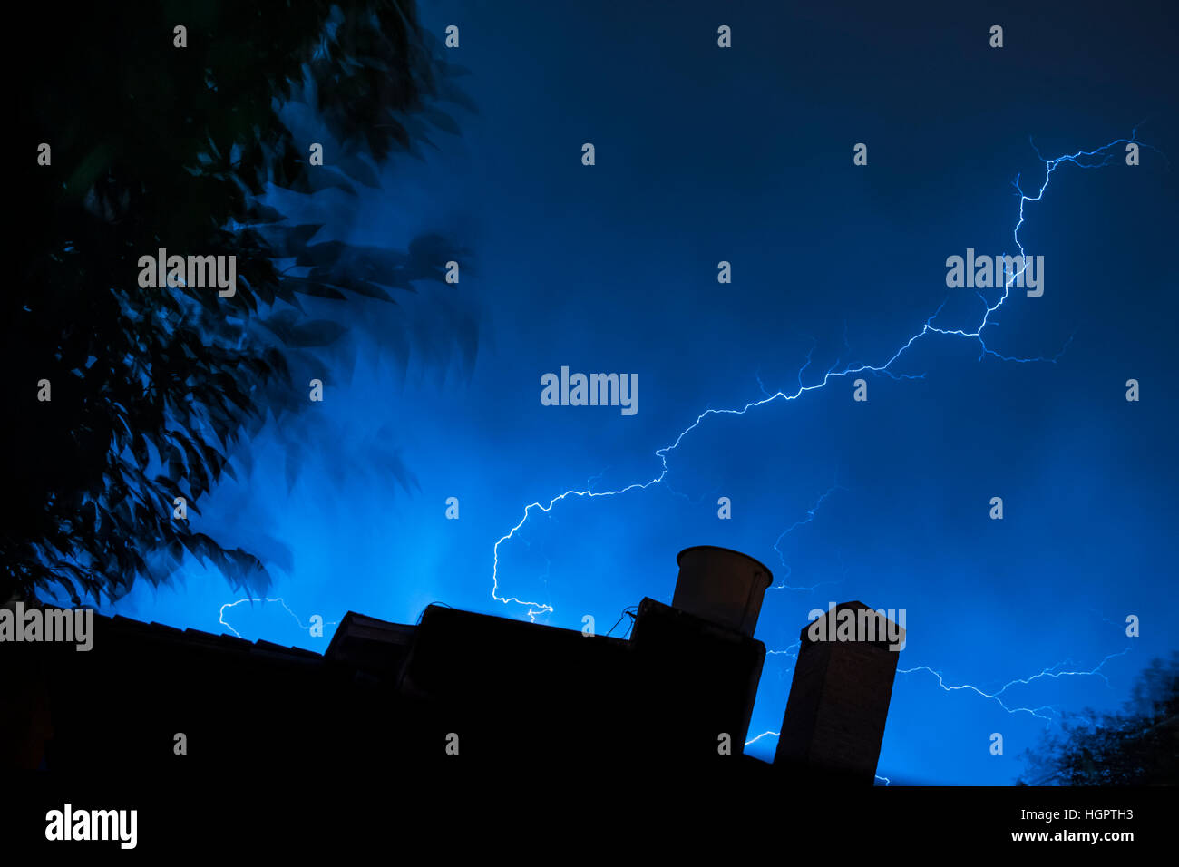 Un fulmine dal cielo striature tetto di una casa a notte Foto Stock