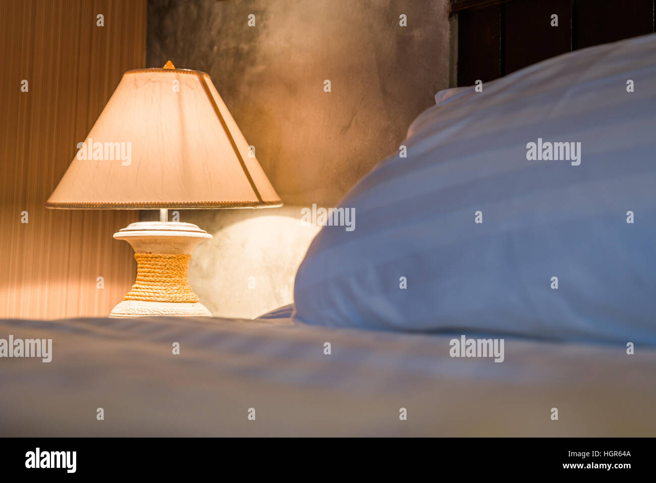 Lampada a letto illuminazione della camera accanto al cuscino Foto Stock