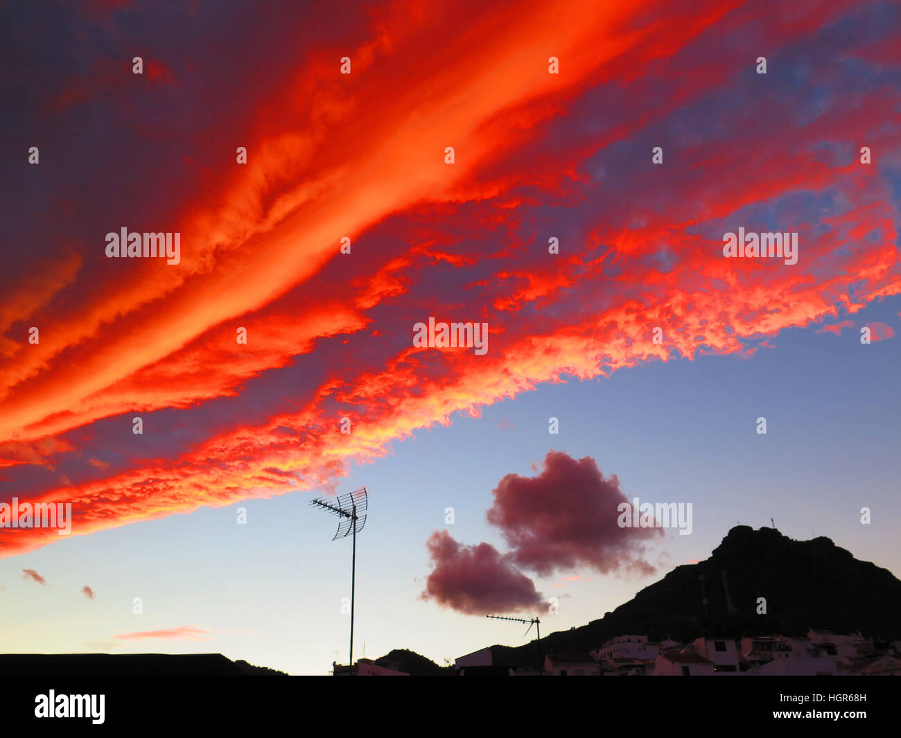 Meteo colorati parte anteriore sopra i tetti di villaggio in Andalusia Foto Stock
