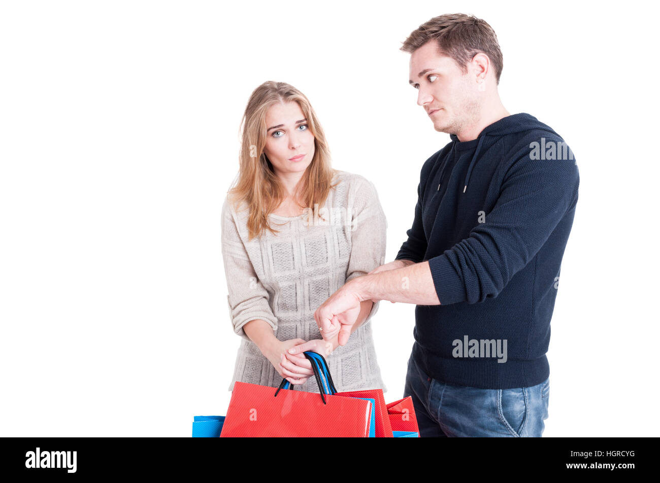 L'uomo rendendo il ritardo al gesto donna azienda shopping bags e baing triste isolato su sfondo bianco Foto Stock