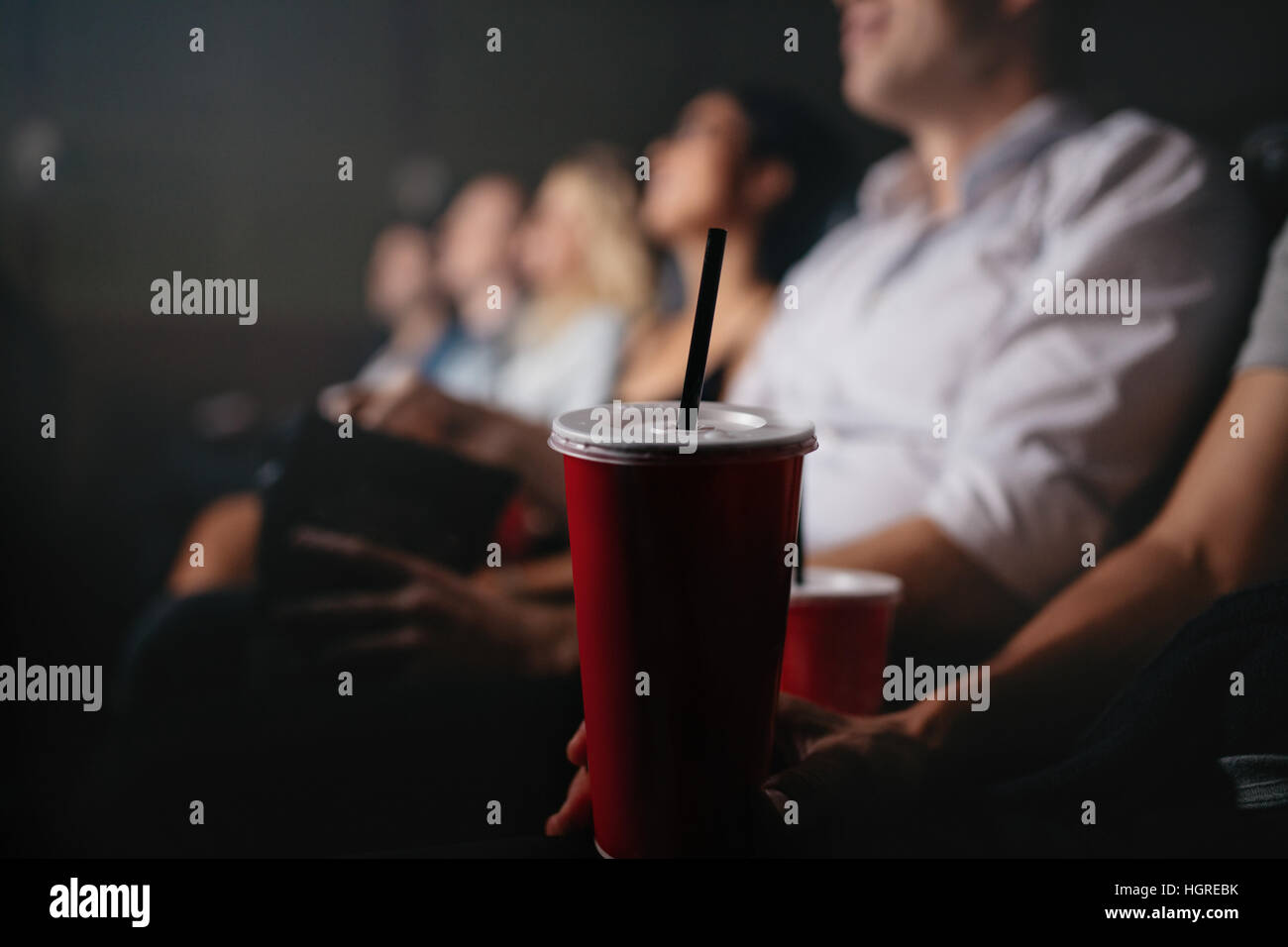 Immagine ravvicinata di giovani con bevande analcoliche in movie theater di concentrarsi sulla bevanda fredda di vetro. Foto Stock