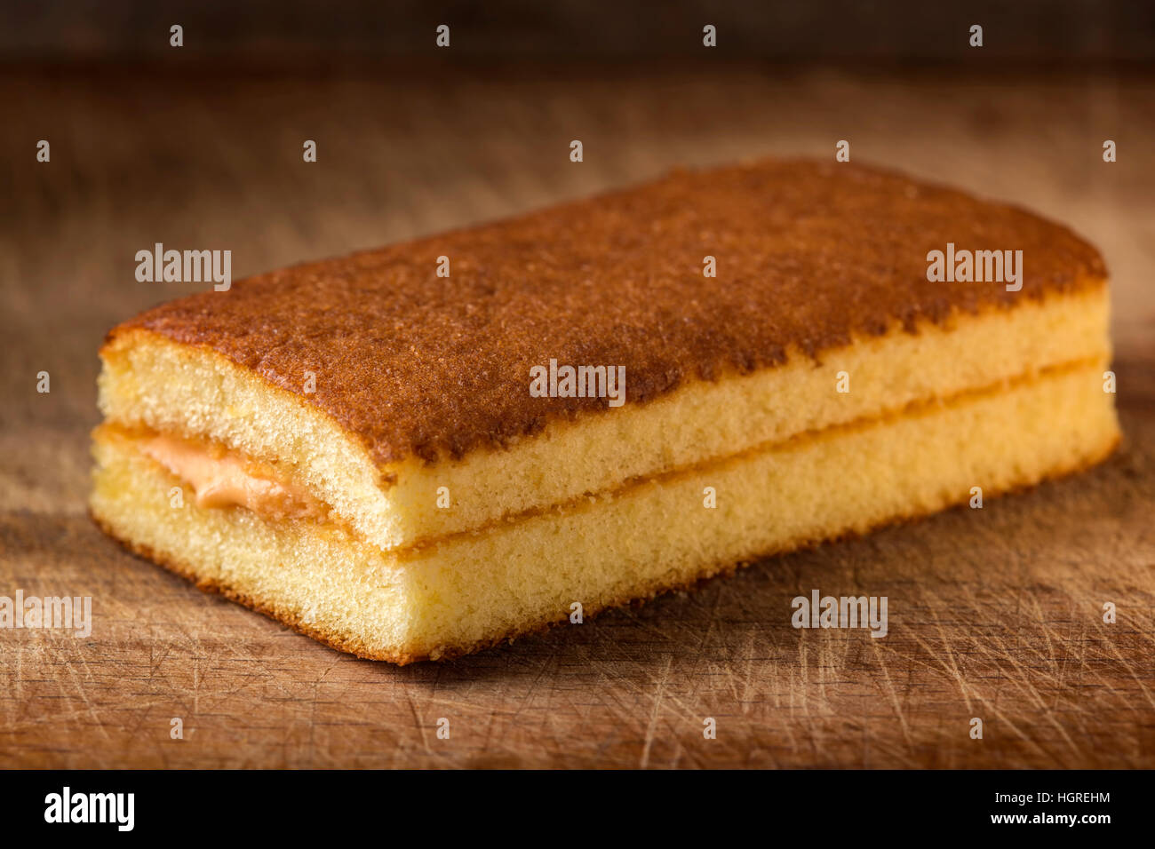 Pan di Spagna con crema di frutta su sfondo di legno Foto Stock