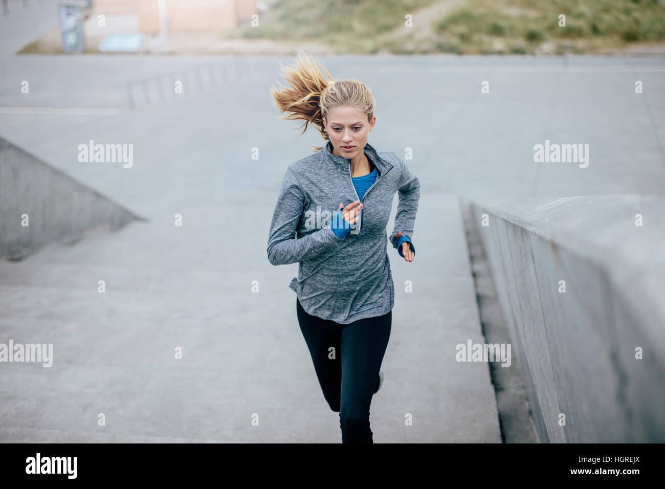 Foto di donna che corre su gradini all'aperto. esercizio fisico femminile al mattino. Foto Stock