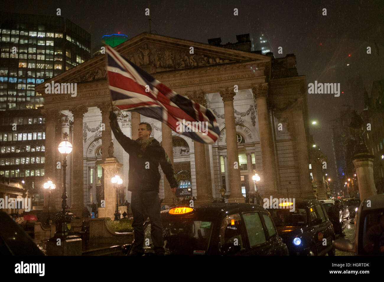 Londra, Regno Unito. Il 12 gennaio 2017. Un Taxi Driver" protesta Banca gridlocks giunzione nel quartiere finanziario di Londra con la loro black cabs, costringendo i ciclisti e i pedoni a tessere attorno al fermo veicoli durante il primo Regno Unito nevi dell'inverno, nella City di Londra, Inghilterra. I piloti stanno protestando che i taxi e altri tipi di traffico sarà bandito da qui, uno di Londra più famigerati giunzioni in una massa di rottura di una misura di sicurezza stradale per avviare nel mese di aprile. Foto di Richard Baker / Alamy Live News Foto Stock