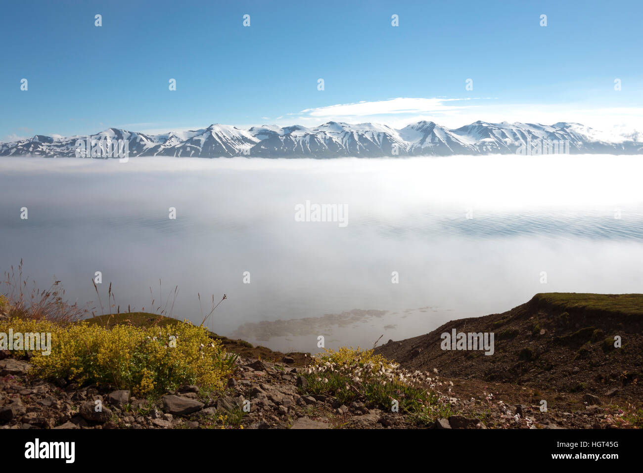 Montagne innevate, nuvole sopra fiordo, Eyjafjörður, Islanda Foto Stock