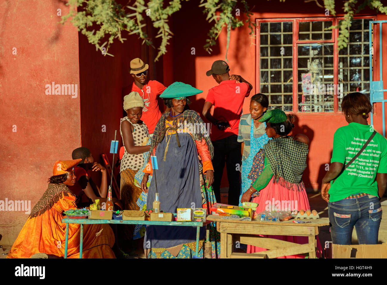 La gente del luogo in abiti colorati in una fase di stallo, Opuwo, Namibia Foto Stock