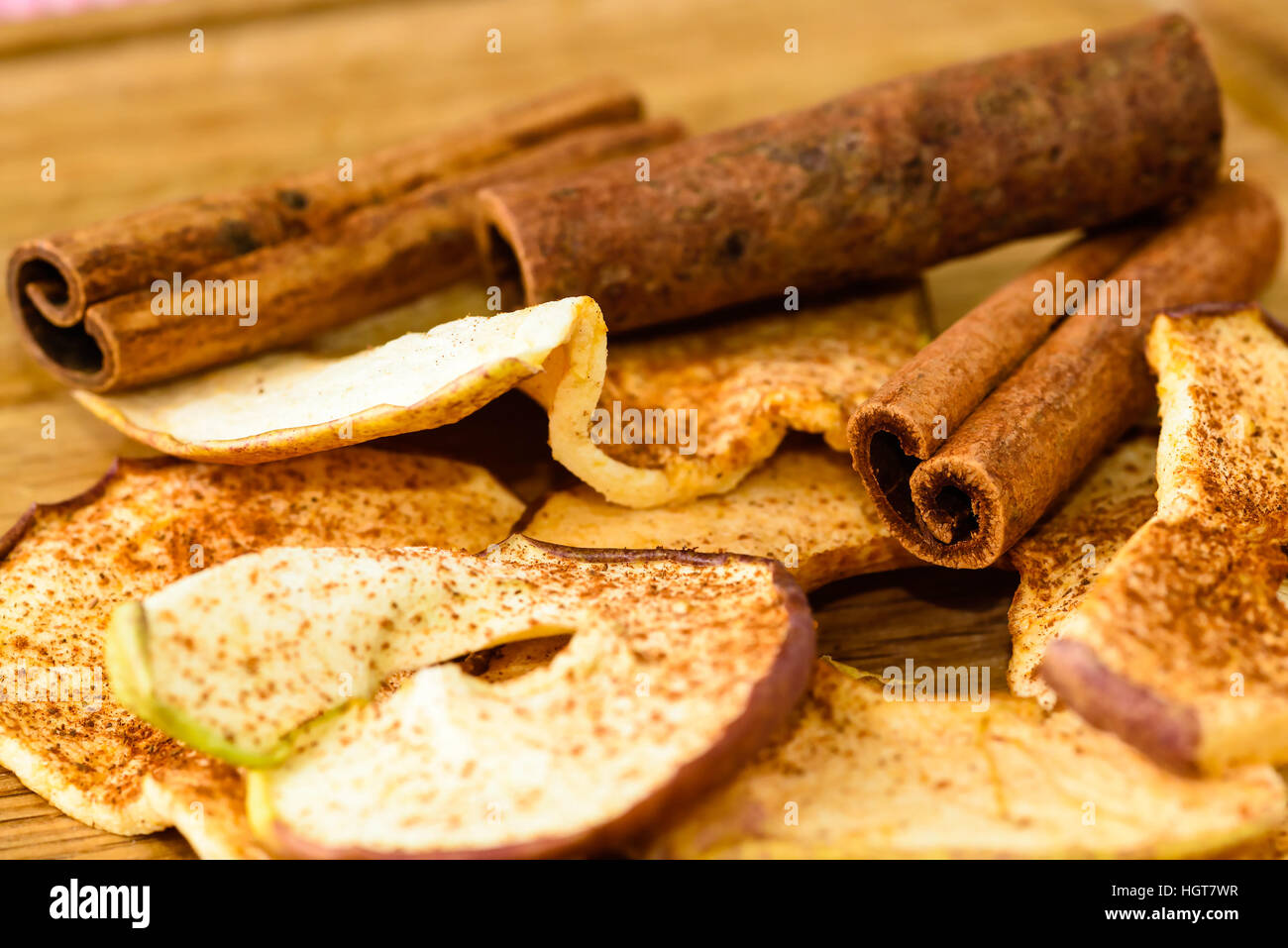 Tutta la cannella e disidratato fette di mela con cannella in polvere sul tagliere di legno. Foto Stock