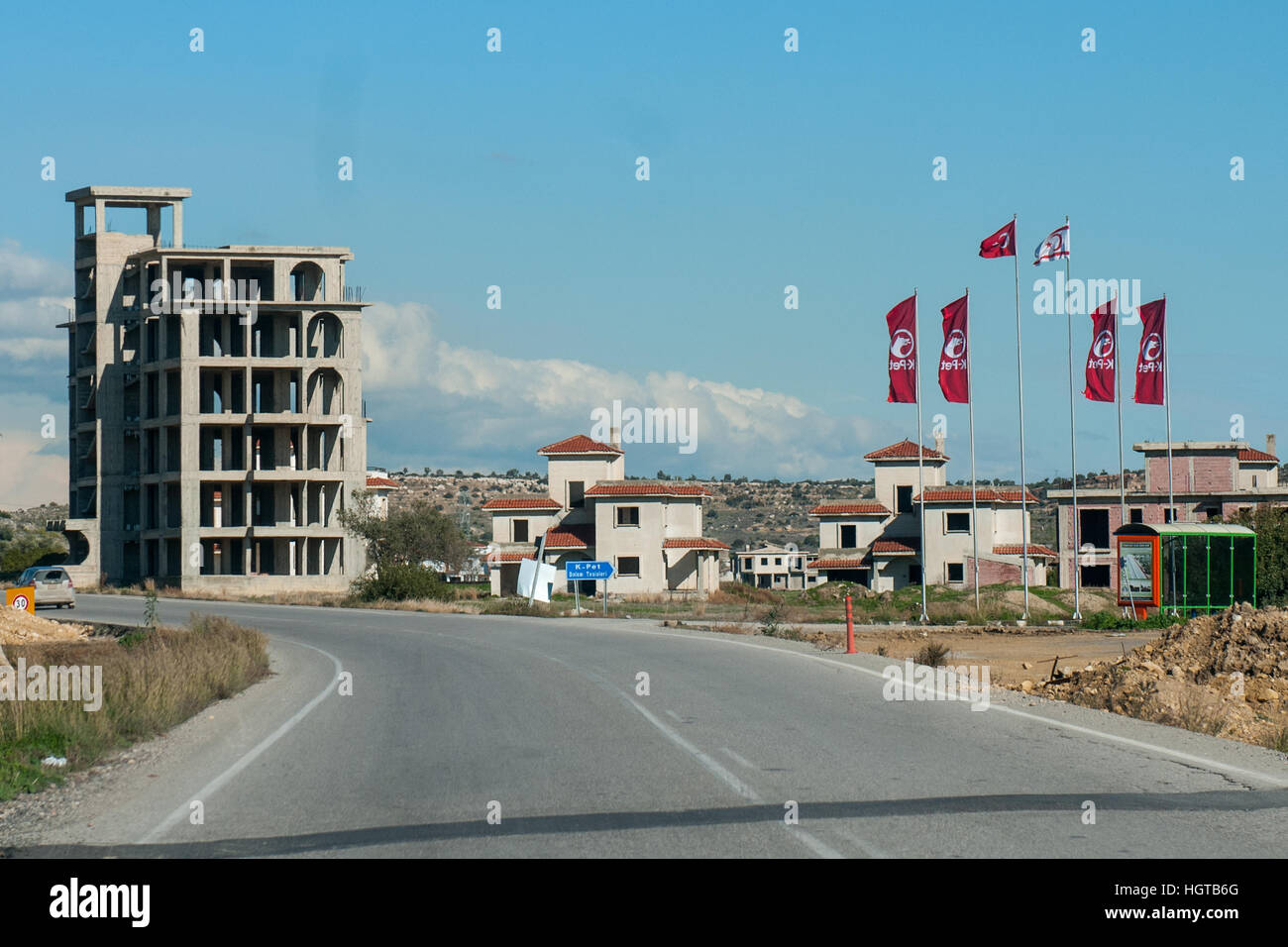 Un palazzo in costruzione e le bandiere della Repubblica Turca di Cipro del Nord. Foto Stock