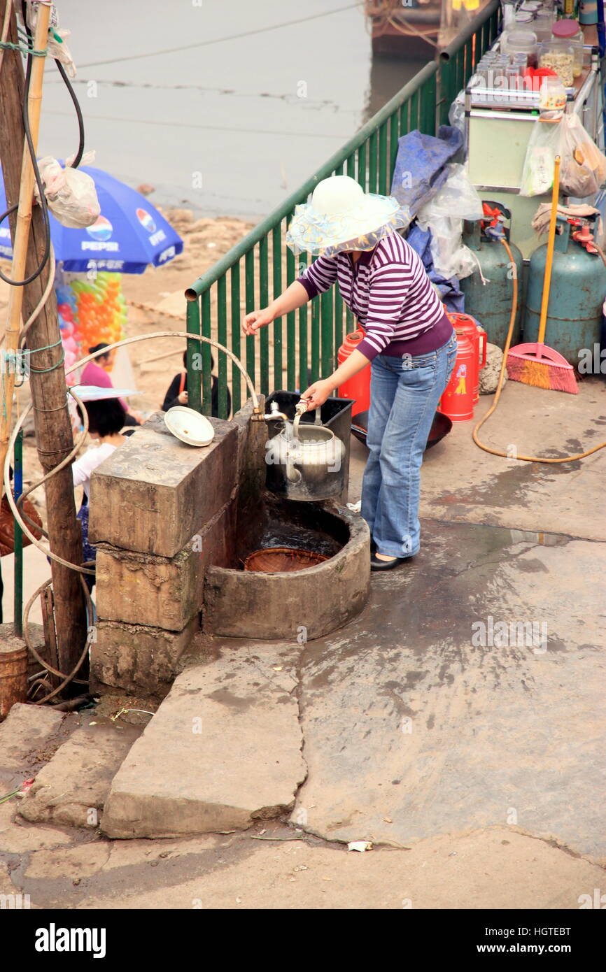 La donna il riempimento di pentola con acqua a Chongqing Cina Foto Stock