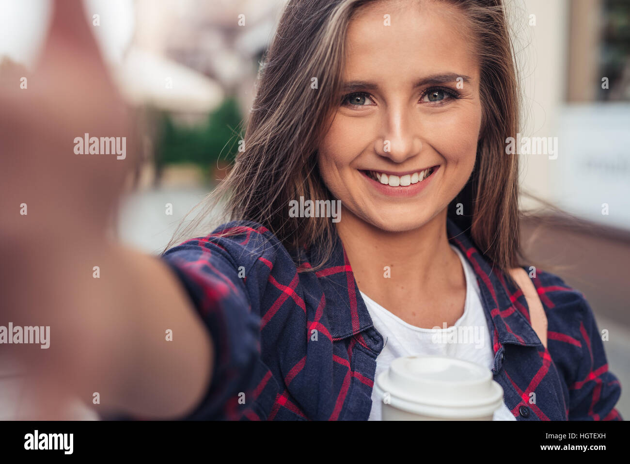 Attraente giovane donna prendendo un selfie nella città Foto Stock
