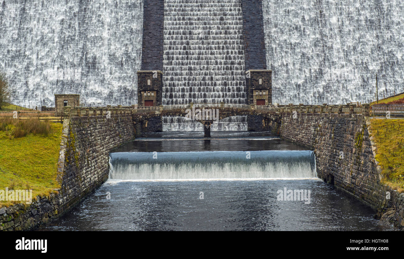 La base della diga Claerwen nella parte superiore della valle Claerwen nel Galles Centrale con acqua a cascata verso il basso Foto Stock