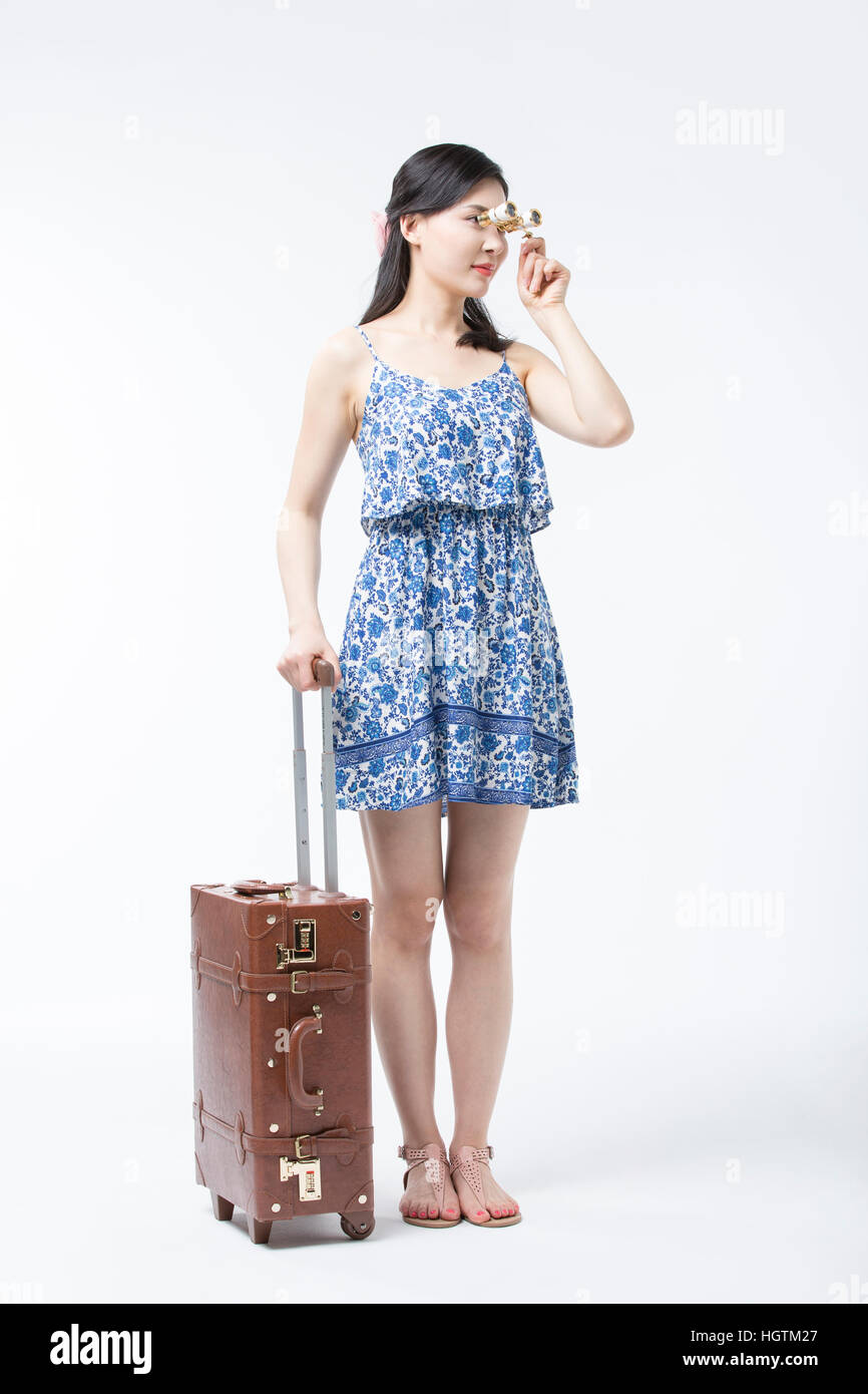 Giovane donna in abiti estivi con il binocolo e permanente del gestore Foto Stock