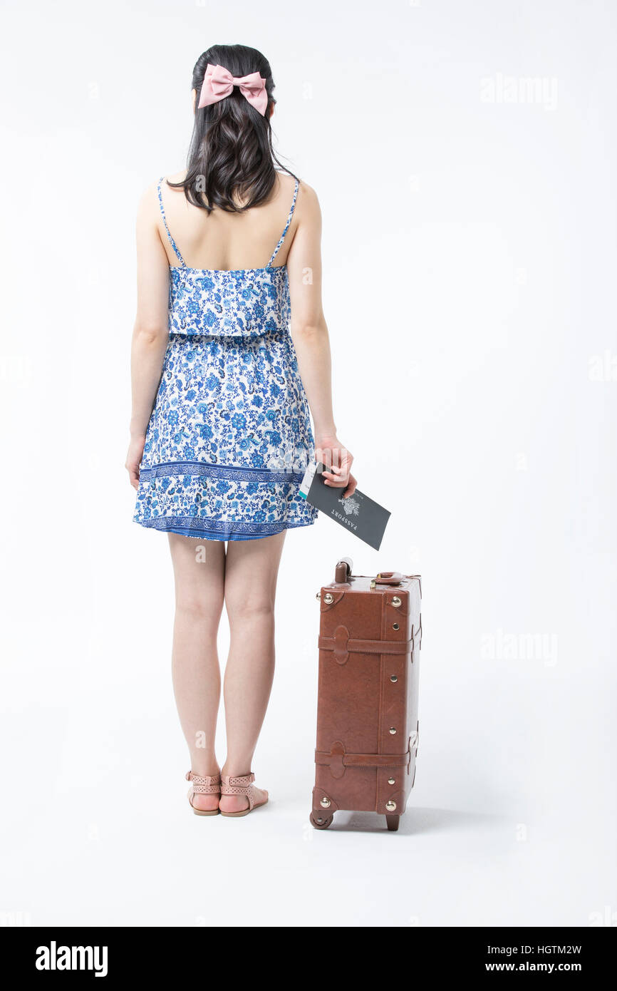 Retro della giovane donna in abiti estivi con biglietto aereo e vettore Foto Stock