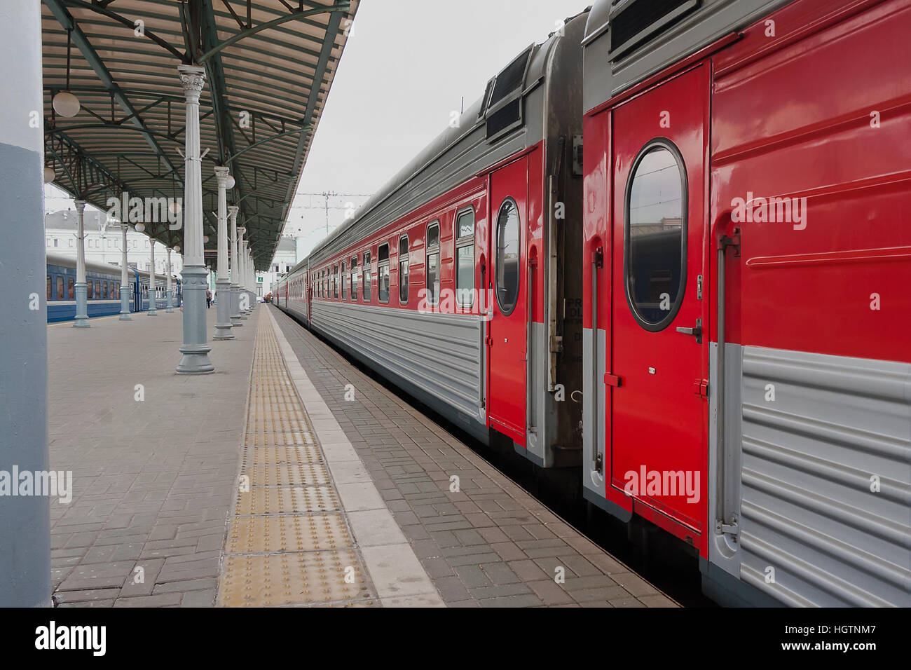Treni passeggeri sulla piattaforma della stazione ferroviaria Foto Stock