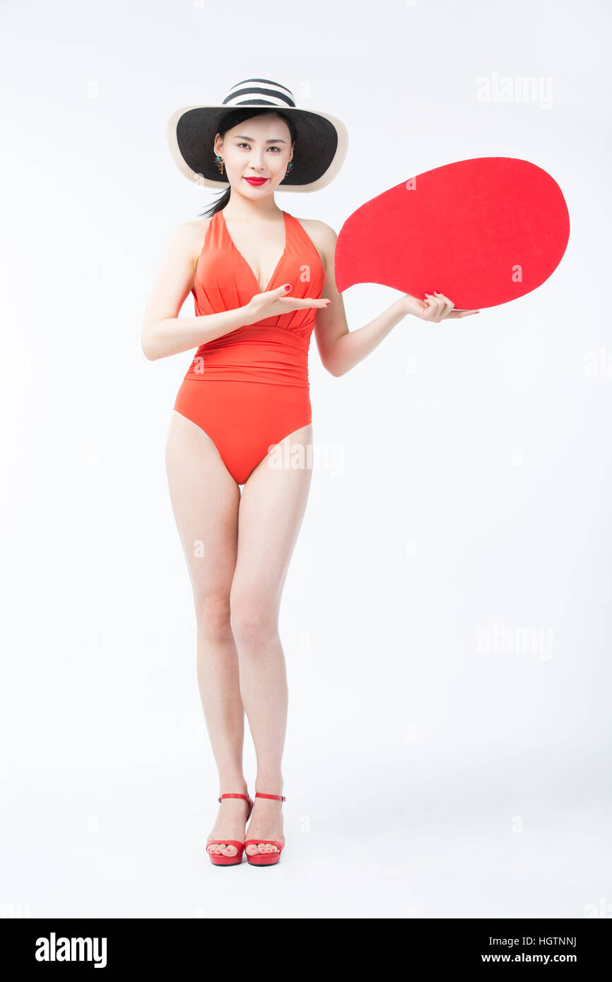 Giovane donna in costume da bagno e hat in posa con il discorso di palloncino Foto Stock