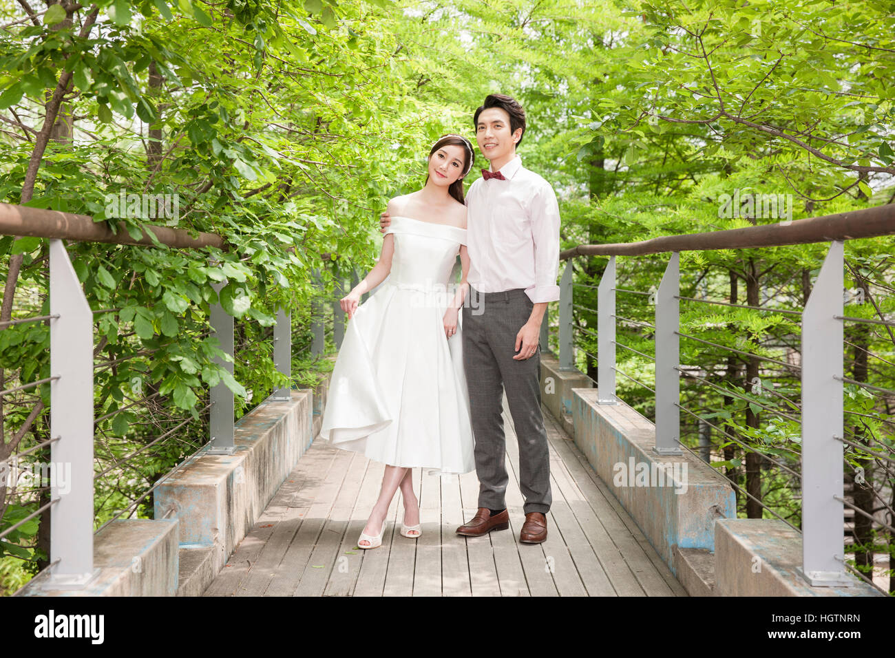 Giovane romantico sposi in posa tenendo le mani all'aperto Foto Stock