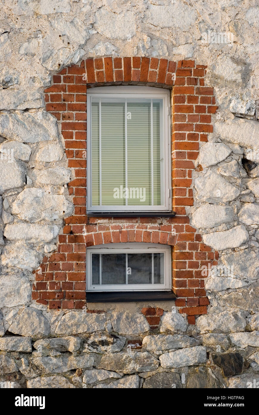 La nuova finestra di plastica nell'antico muro di pietra Foto Stock