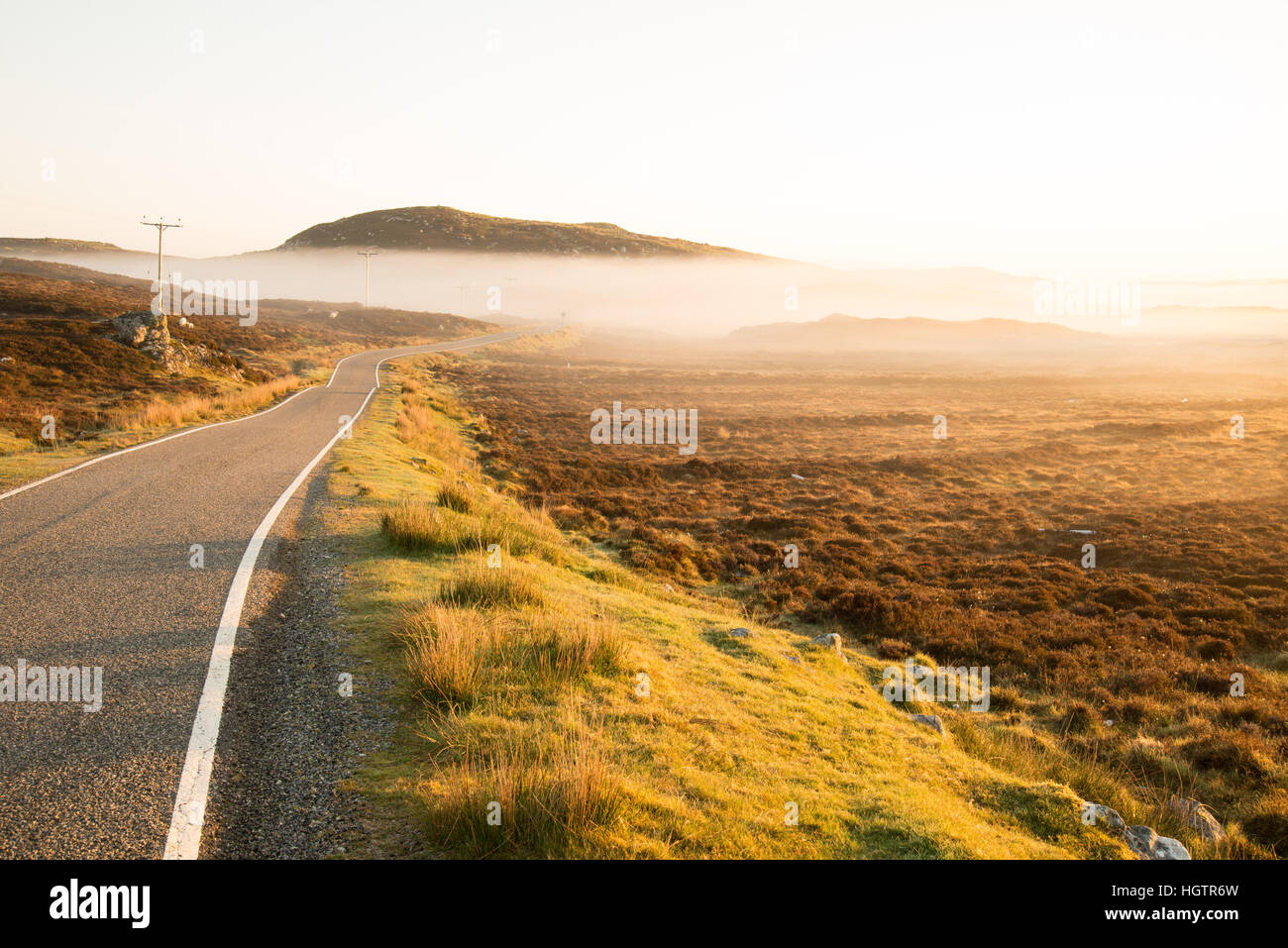Via unica strada in Scozia su foschia mattutina nelle Ebridi Esterne Foto Stock