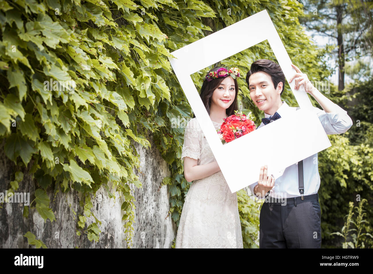 Romantico sorridenti sposi in posa con un telaio esterno Foto Stock