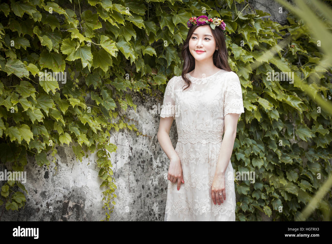 Giovane sposa sorridente con fiori sul suo capo all'aperto Foto Stock
