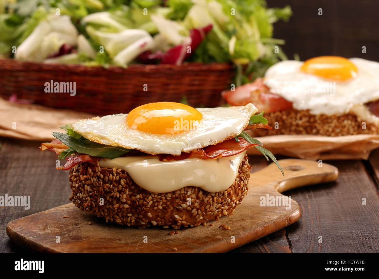 Panino con formaggio pancetta e uova fritte su sfondo di legno Foto Stock