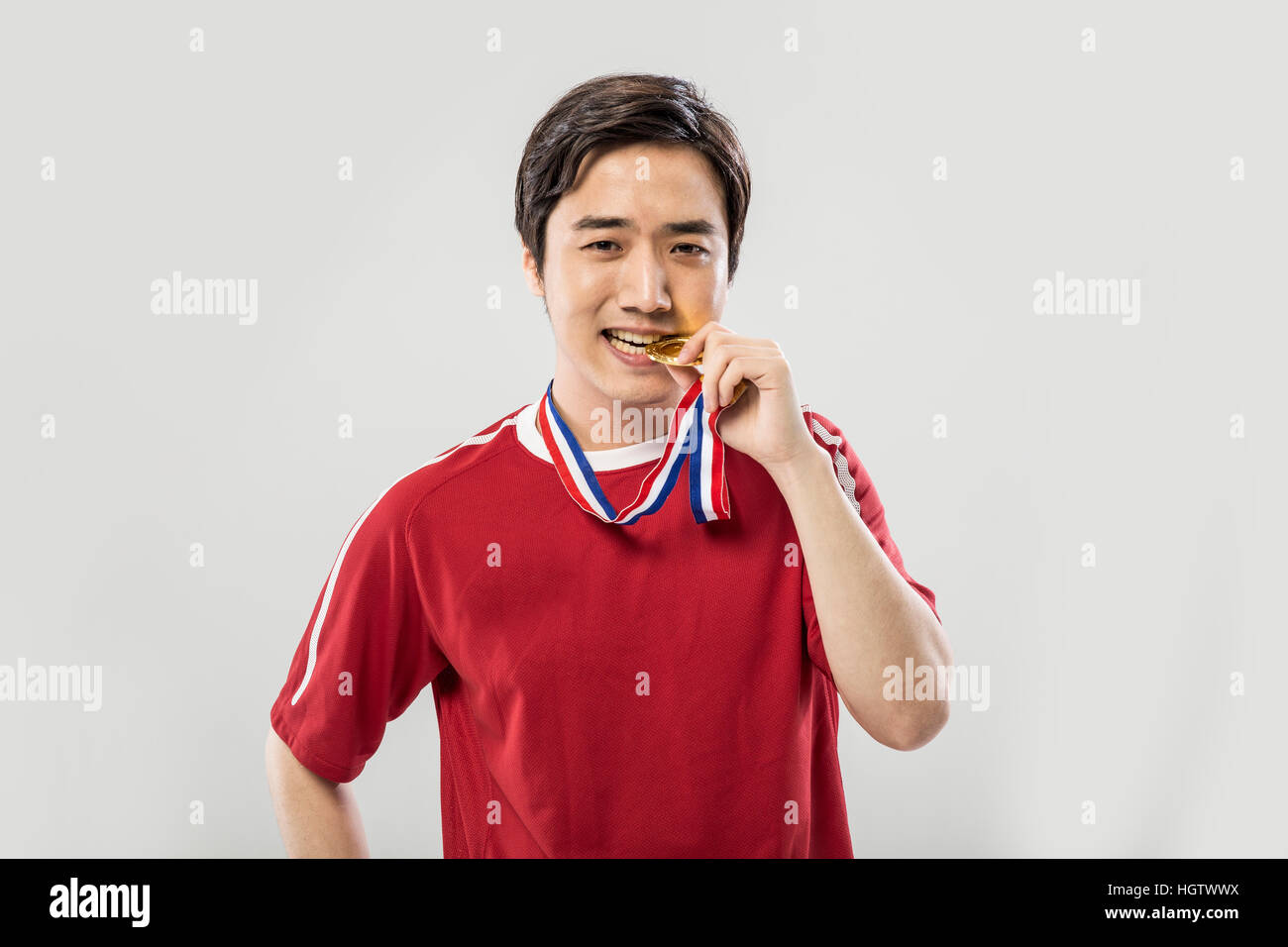 Ritratto di giovane sorridente maschio coreano Sports player con medaglia d'oro Foto Stock