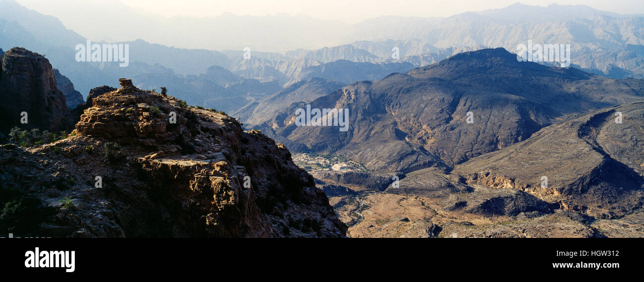I ripidi pendii delle zone aride montagne frastagliate che si affaccia su un eroso e inospitale deserto roccioso valley. Foto Stock