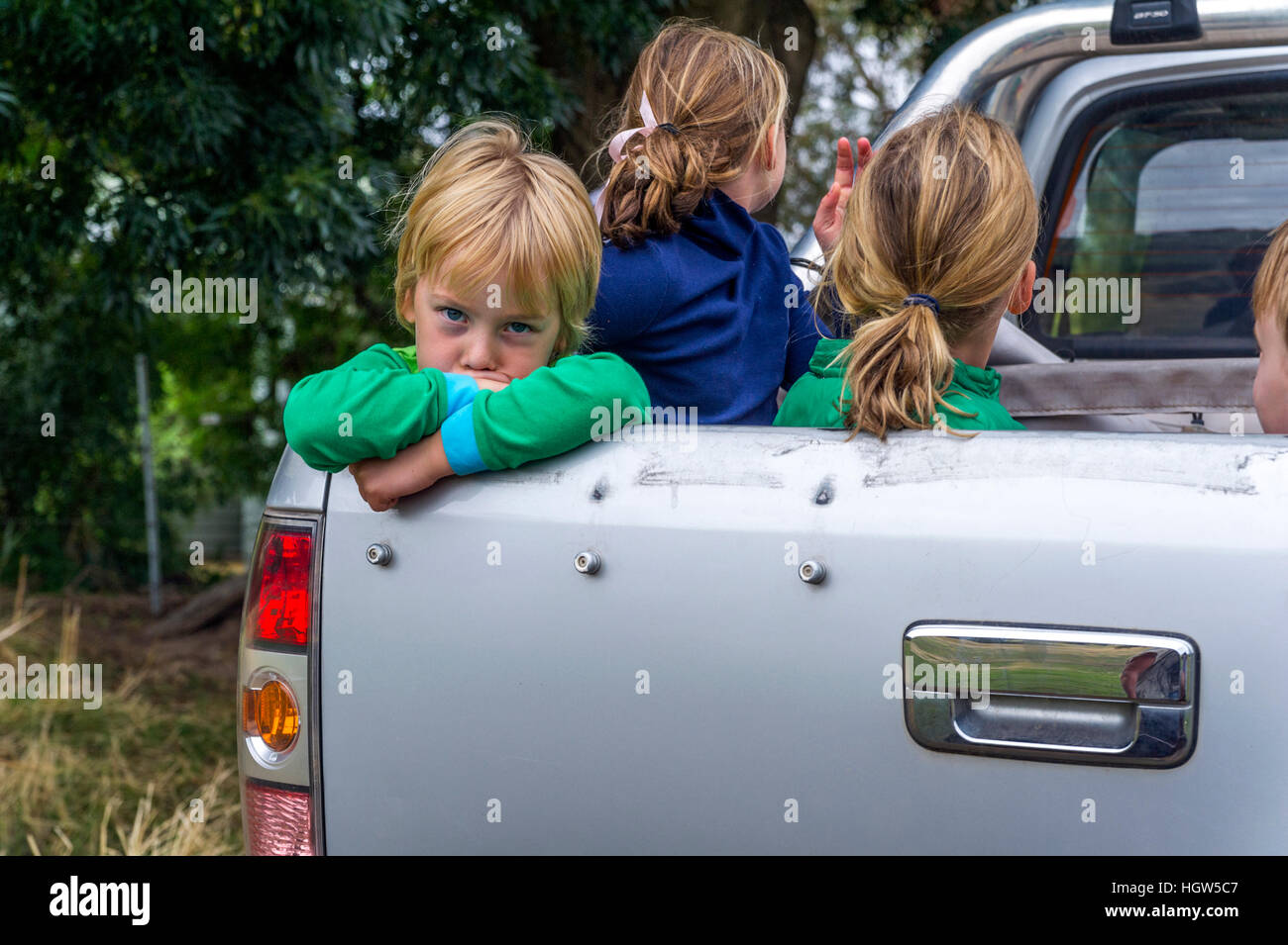 Bambini viaggiare nel retro di un veicolo utilitario in una fattoria. Foto Stock