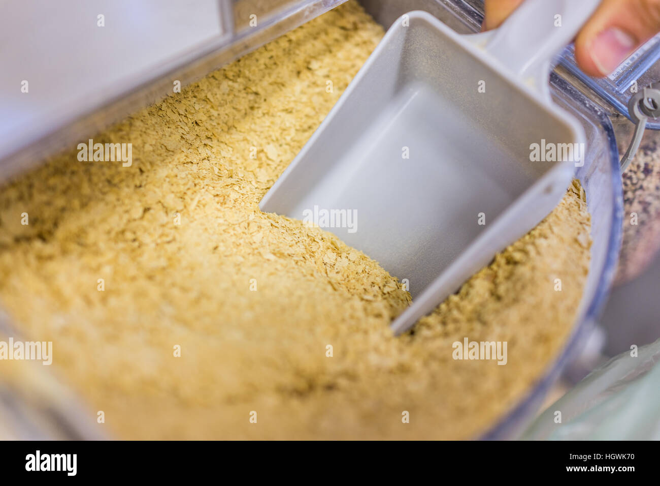 Persona di movimentazione di lievito nutrizionale dalla sezione di bulk Foto Stock